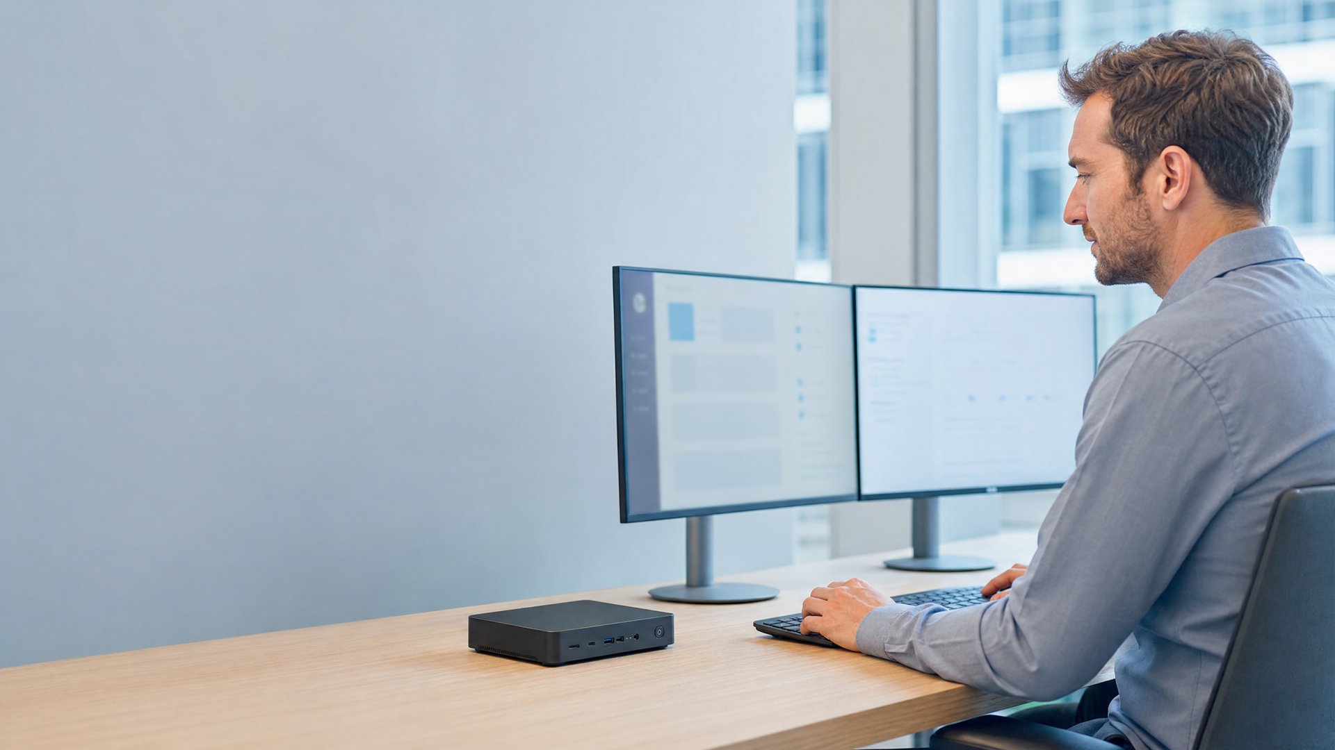 Mitarbeiter arbeitet am virtuellen Arbeitsplatz mit Thin Client und zwei Monitoren